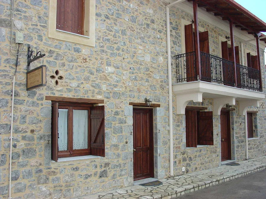 Η πέτρινη πρόσοψη με τα ξύλινα παραθυρόφυλλα